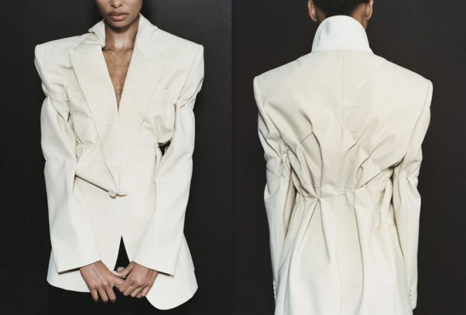 Two angles of a person modeling a cream-colored blazer with puffy sleeves against a dark backdrop in a studio fashion shot.
