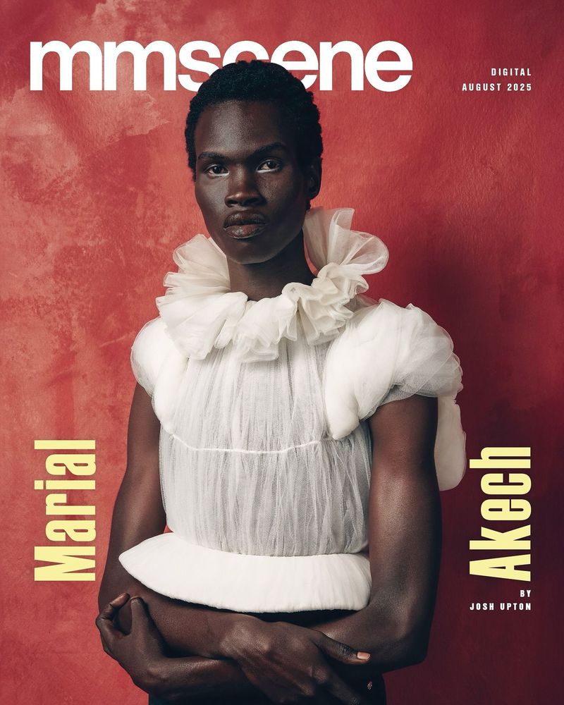 Magazine cover featuring a Black male model wearing a white ruffled collar and top against a textured red backdrop. Fashion editorial.