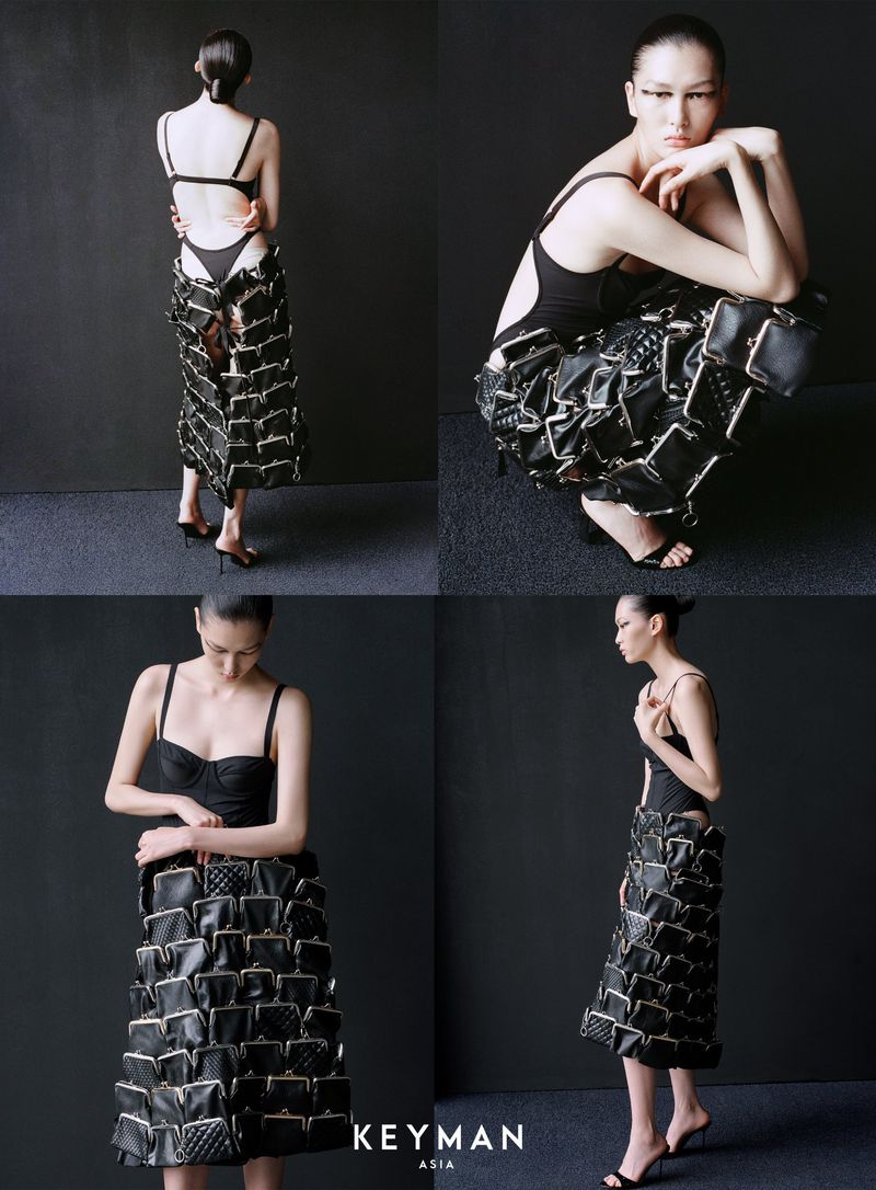 A fashion editorial shot showcases a woman in a black bodysuit and skirt made of coin purses, set against a dark gray backdrop.