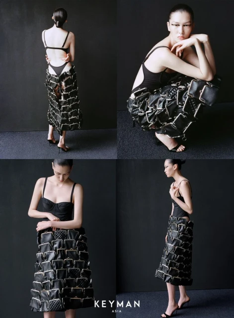 A fashion editorial shot showcases a woman in a black bodysuit and skirt made of coin purses, set against a dark gray backdrop.