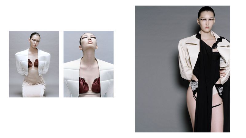 Avant-garde fashion photography featuring a woman in a stylish white jacket and black dress against a grey backdrop. Studio lighting is used.