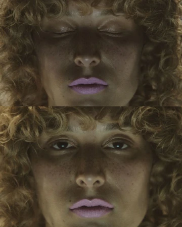 A split-screen close-up captures a young woman's face, once with eyes closed and once with eyes open, freckled skin and curly hair.