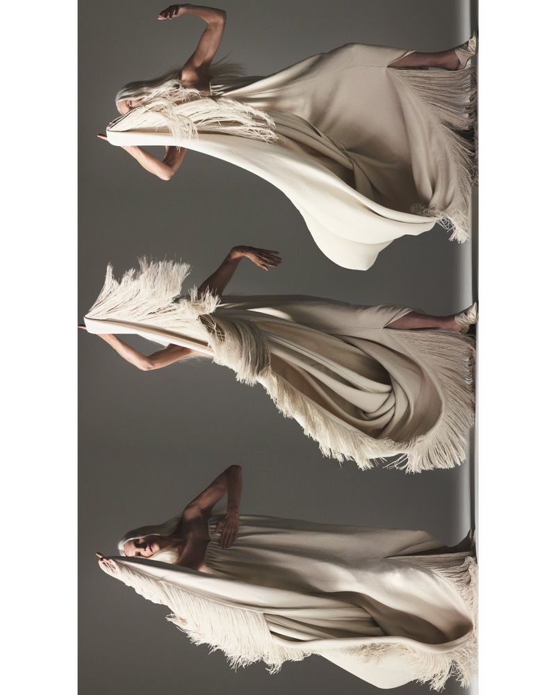 Fashion shot features a woman wearing a draped, off-white dress with fringe in three different poses against a gray backdrop.