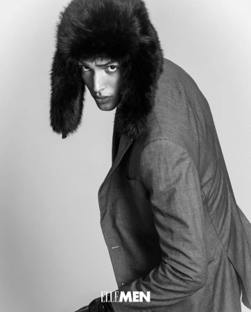Portrait of a man in a grey suit and fur ushanka hat against a white background, fashion photography, black and white.