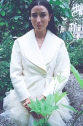 Lily Kwong wearing a cream white blazer jacket outdoors among garden greenery for Cero Magazine