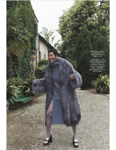 Model Laiza de Moura in a grey fur coat and turtleneck walking along a garden path for Madame Germany Reich & schön