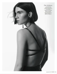 Model in black strap dress with statement earrings against a plain white background for Madame Germany Role Models editorial