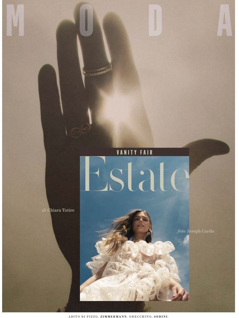 Vanity Fair magazine cover featuring a fashion model in a white lace dress against a blue sky, partially obscured by a hand shadow.