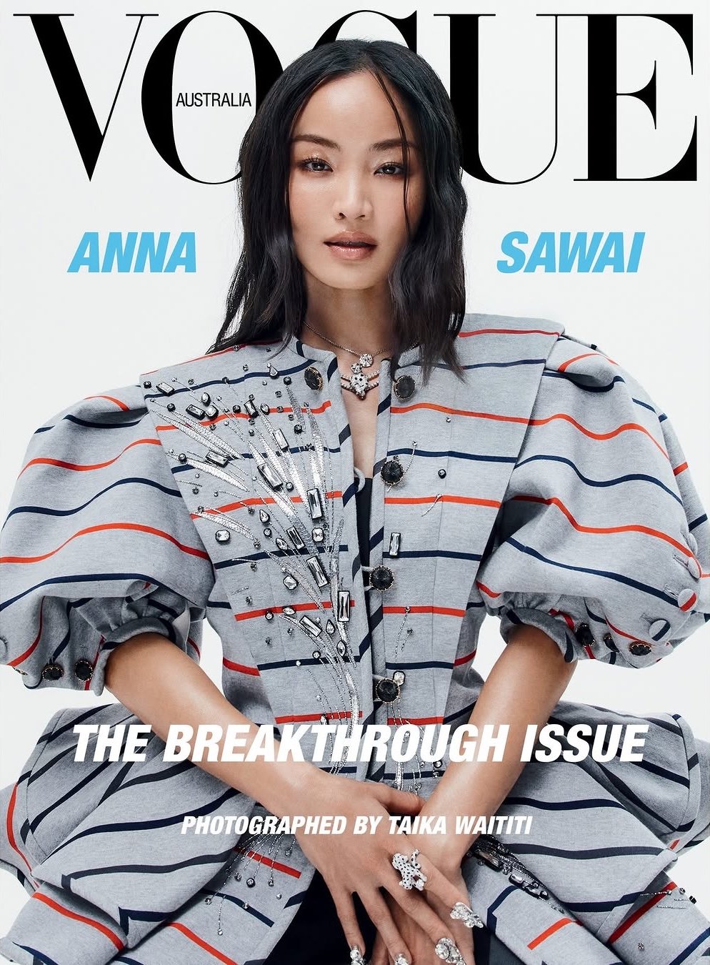 Vogue Australia cover featuring Anna Sawai in a striped jacket with embellished detail, wearing rings, neutral makeup, and black hair.
