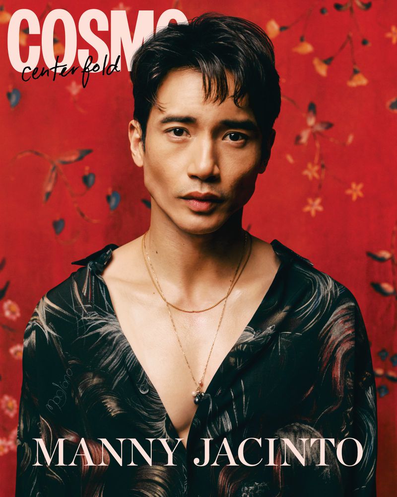 Portrait of Manny Jacinto on a magazine cover with a patterned shirt against a red floral background, bathed in soft, diffused lighting.