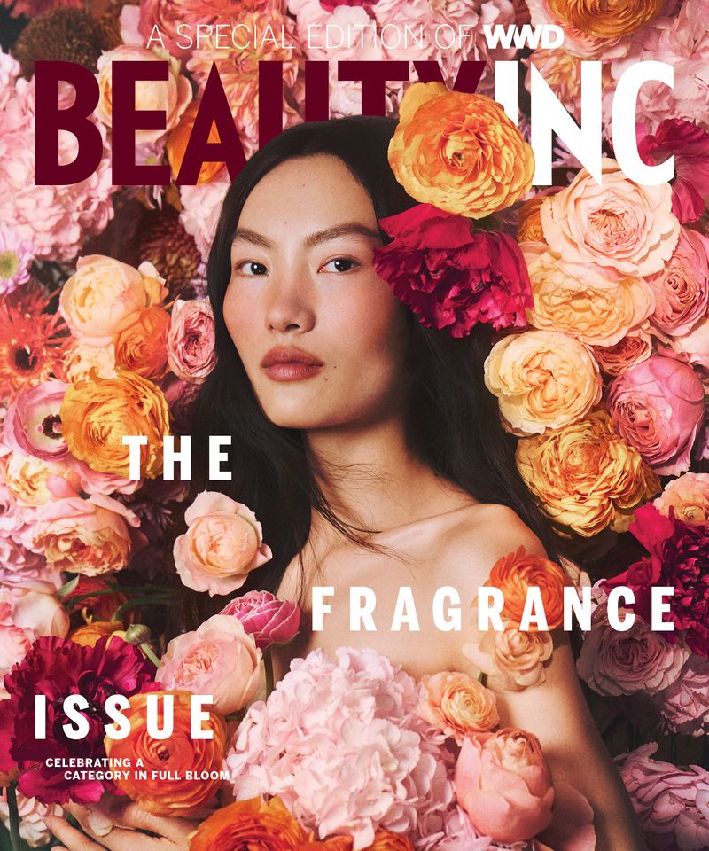 Beauty Inc. fragrance issue cover featuring a model surrounded by colorful flowers in a close-up studio shot with floral decorations.