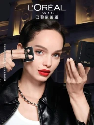 Model Luma Grothe applying powder foundation with a compact puff wearing a black leather jacket for L'Oreal Paris.