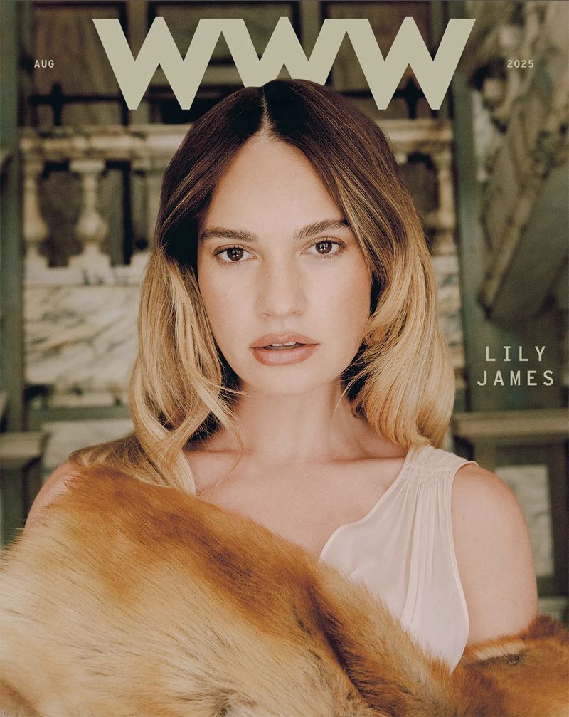 Lily James on a magazine cover. A blond woman poses in front of a marble wall wearing a fur stole and white top for the shoot.
