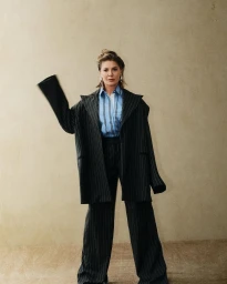 Natalie Bassingthwaighte in a pinstripe suit and blue shirt posing for Stellar Magazine