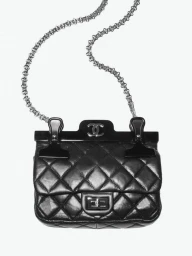 Black quilted leather handbag with silver chain strap and binder clips on a white background
