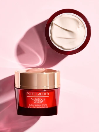 Estee Lauder Nutritious Vitality8 Radiant Moisture Creme jar and open lid on a pink background with studio lighting and shadow.