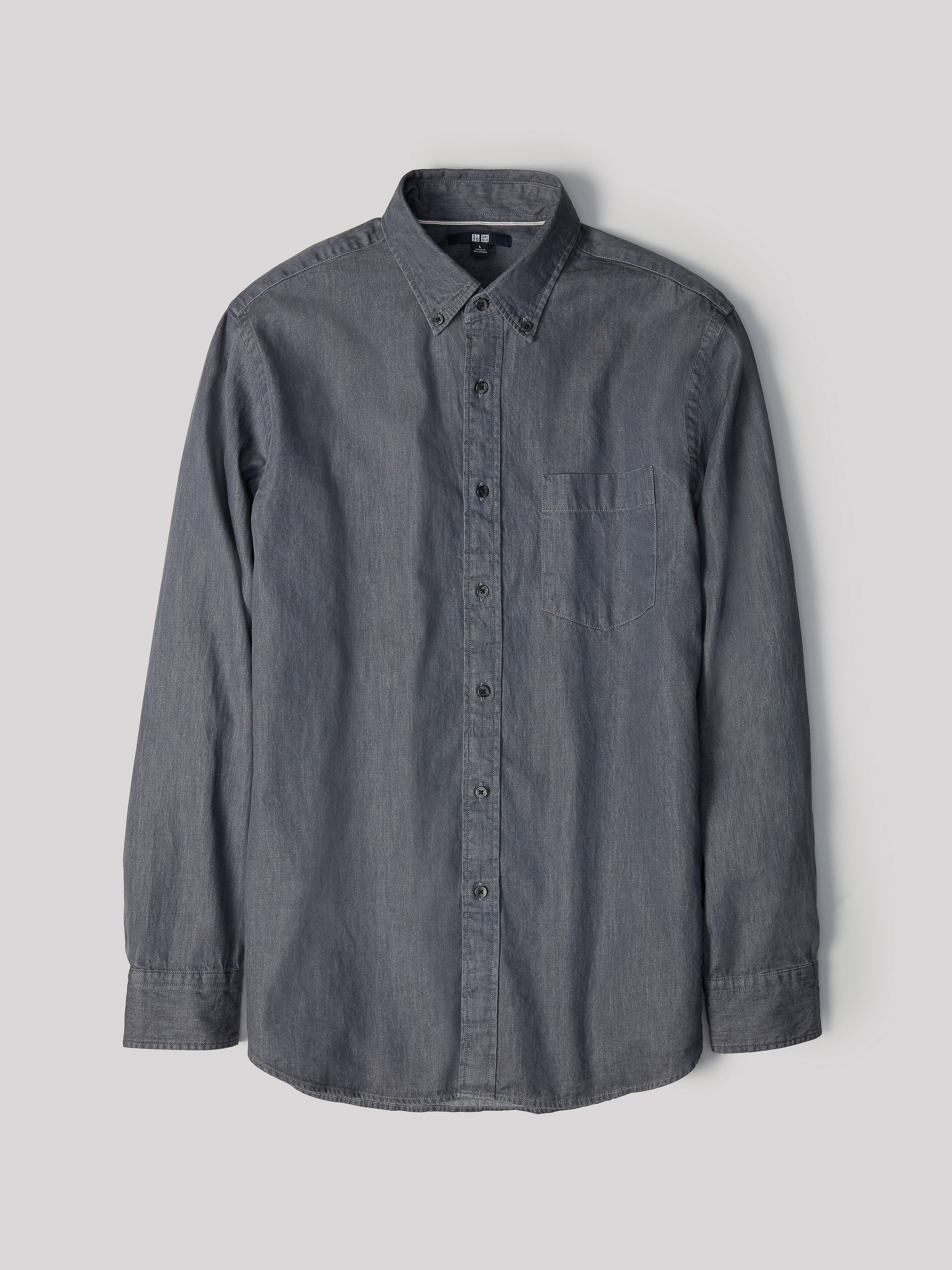 Studio shot of a gray, long-sleeved button-down shirt with a pocket. The casual shirt is collared and made of soft cotton.