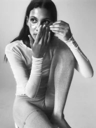 Model wearing under-eye patches applying skincare tool against a light seamless background for The Last Magazine editorial