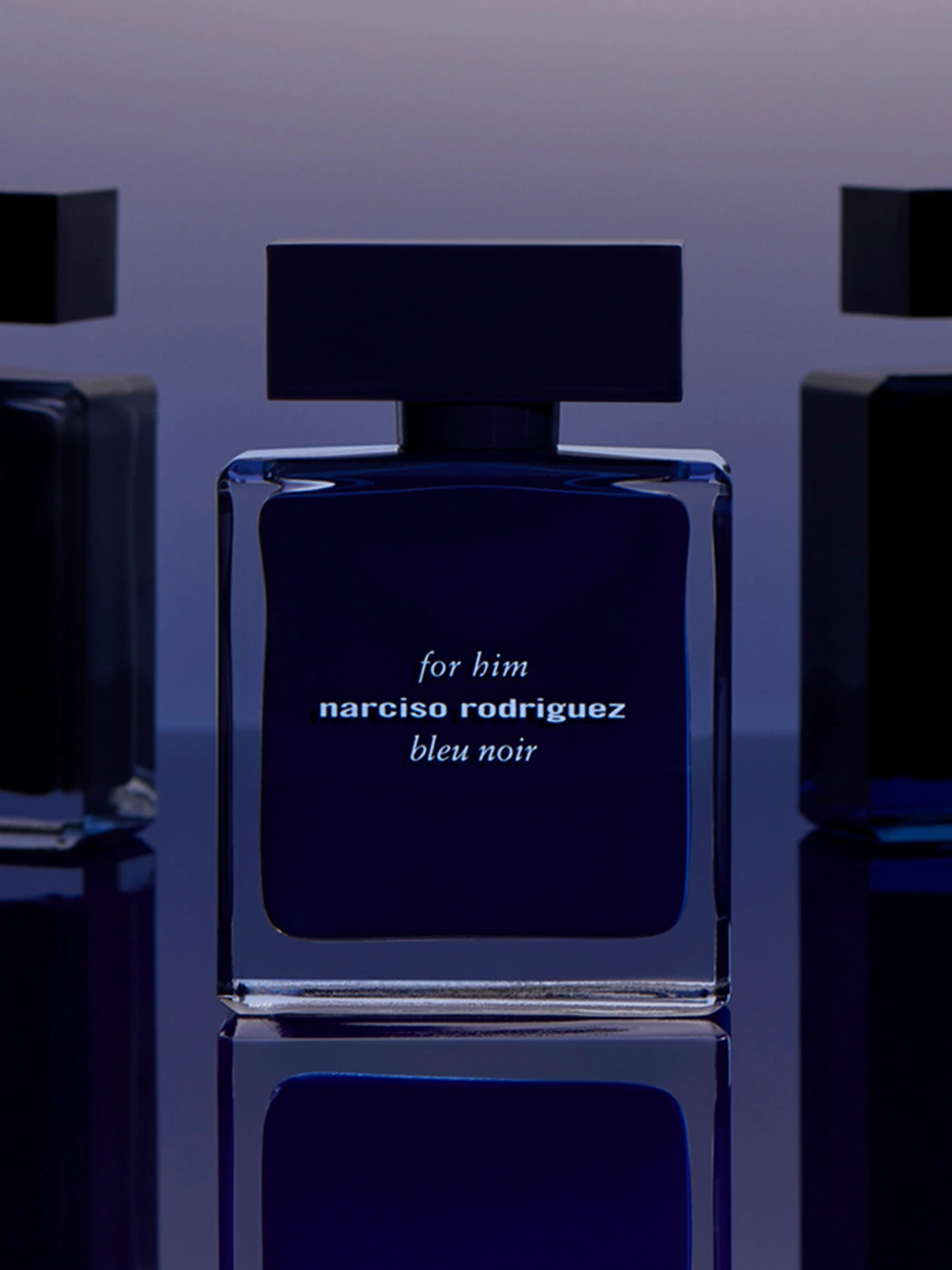 Narciso Rodriguez bleu noir fragrance bottle centered on a reflective surface against a gradient purple and blue background