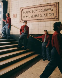 Multiple exposures of a man in a red shirt and grey trousers on stairs beneath a tiled subway sign for InStyle Australia