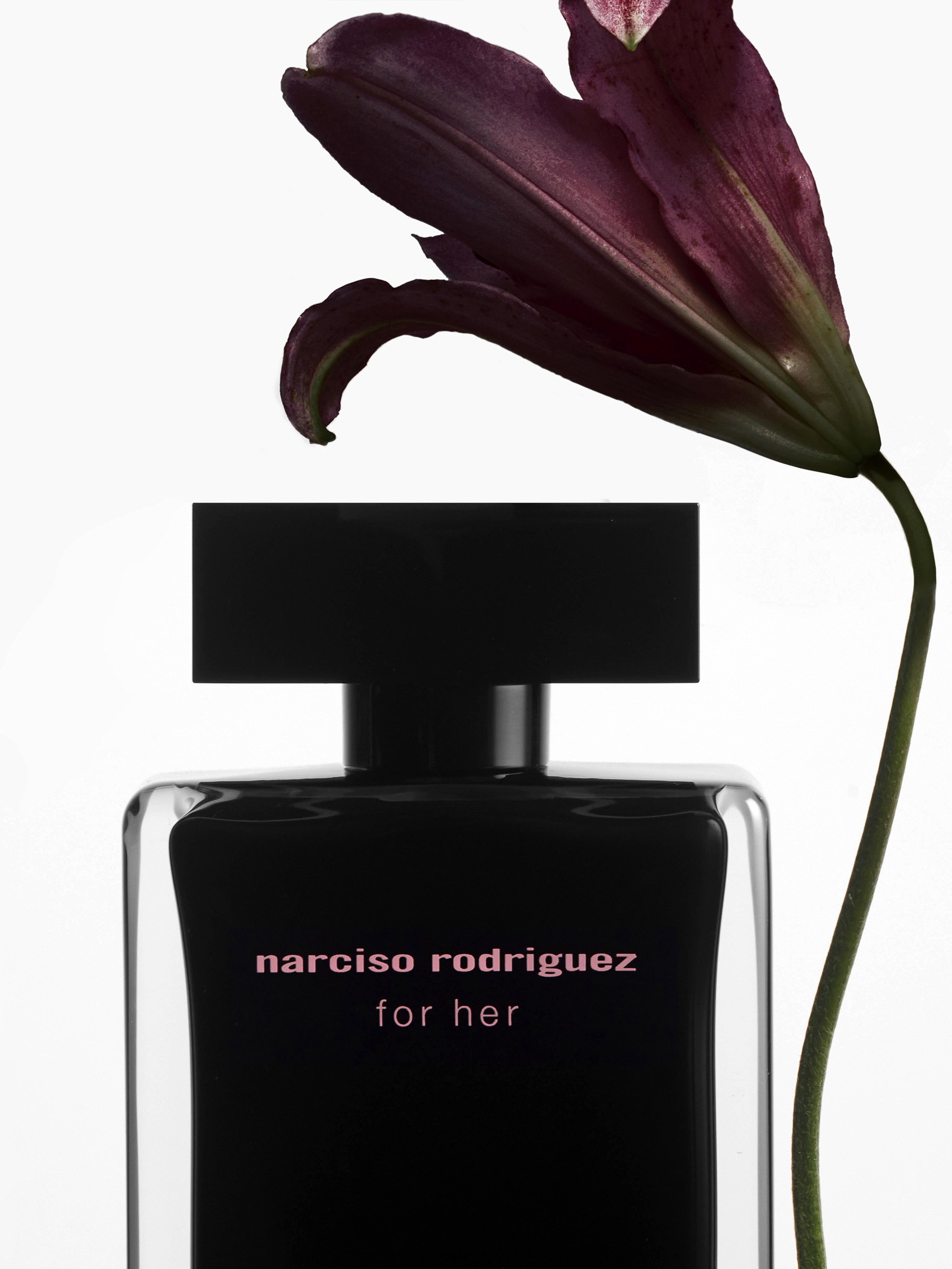 Narciso Rodriguez For Her perfume bottle with a dark floral accent, product shot with a clean, minimalist aesthetic, beauty advertisement.