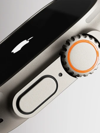 Macro studio shot of a titanium Apple Watch Ultra with an orange action button and crown, showcasing its sleek design and functionality.