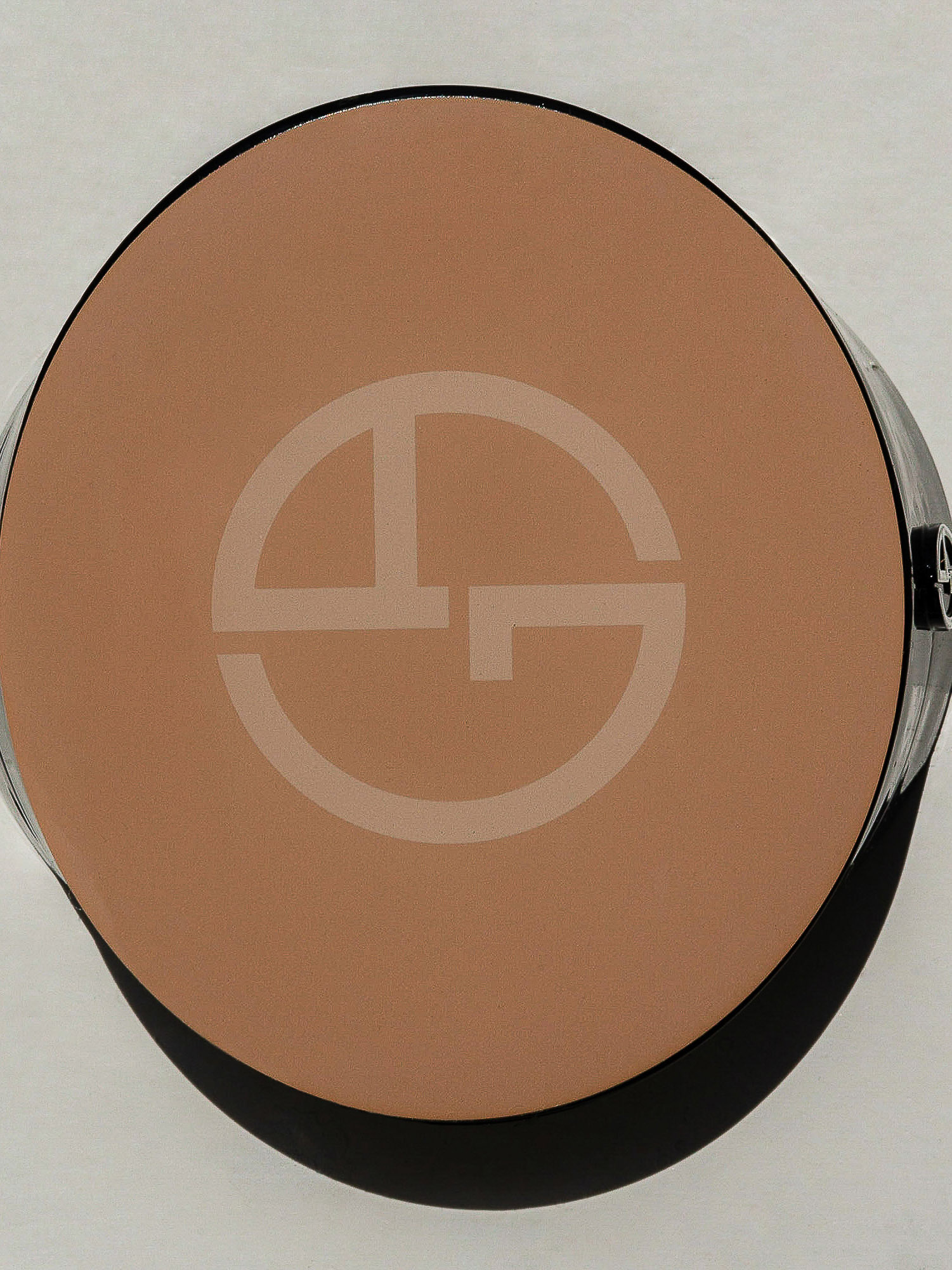 Overhead close-up of Giorgio Armani Luminous Silk Glow Fusion Powder foundation compact, showcasing a light tan face powder.