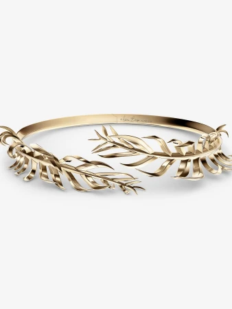 Elegant gold-toned metal headpiece with stylized leaf designs on a white background, perfect for fashion and beauty visuals.