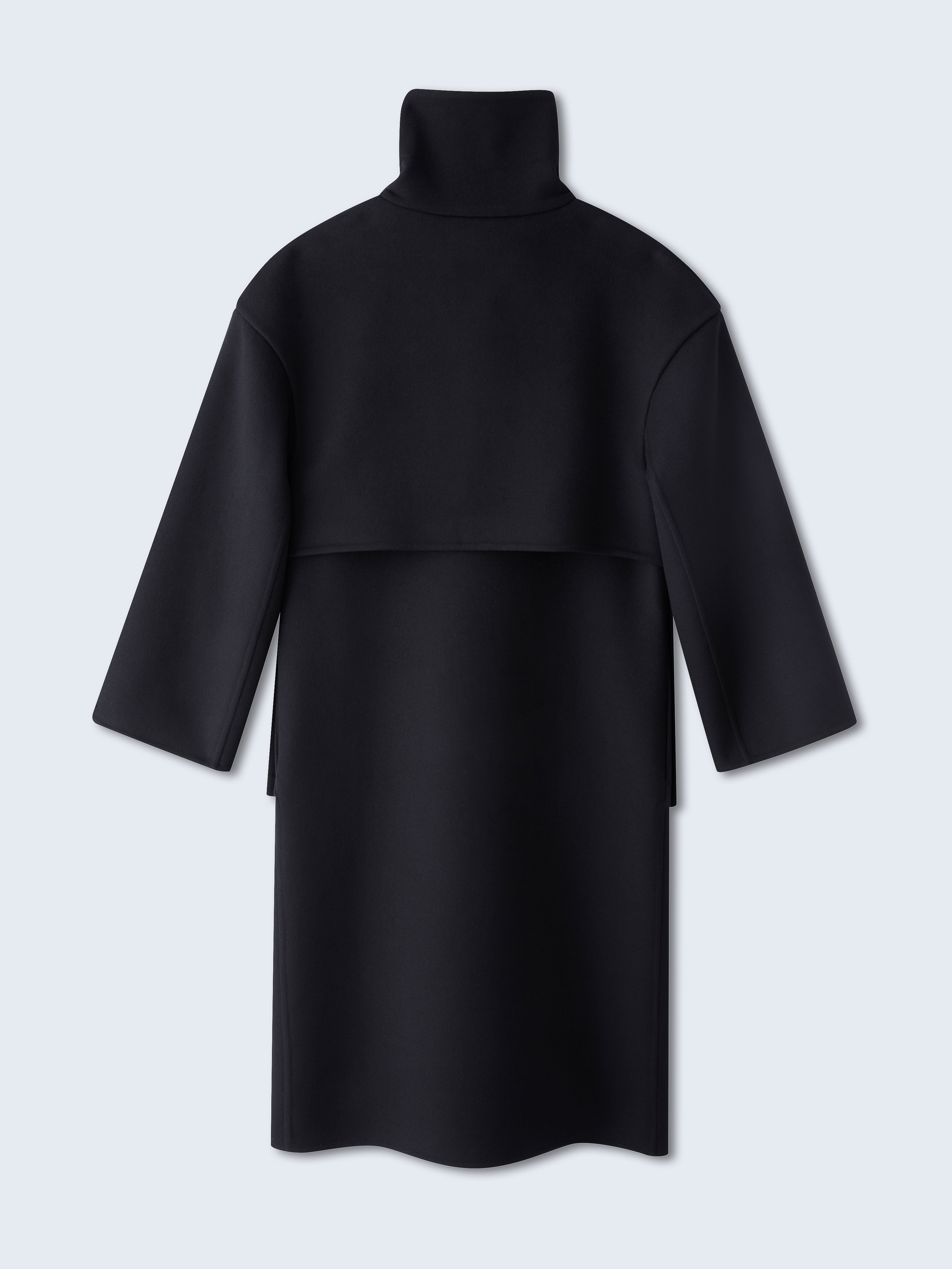 Back view of a black dress with a high collar and long sleeves, set against a neutral background in a studio photography setting.