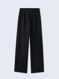 Pair of tailored black wide-leg trousers laid flat against a neutral light grey seamless background.