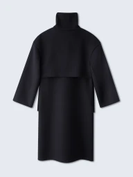 Back view of a structured black high-neck coat with wide sleeves against a plain neutral background.