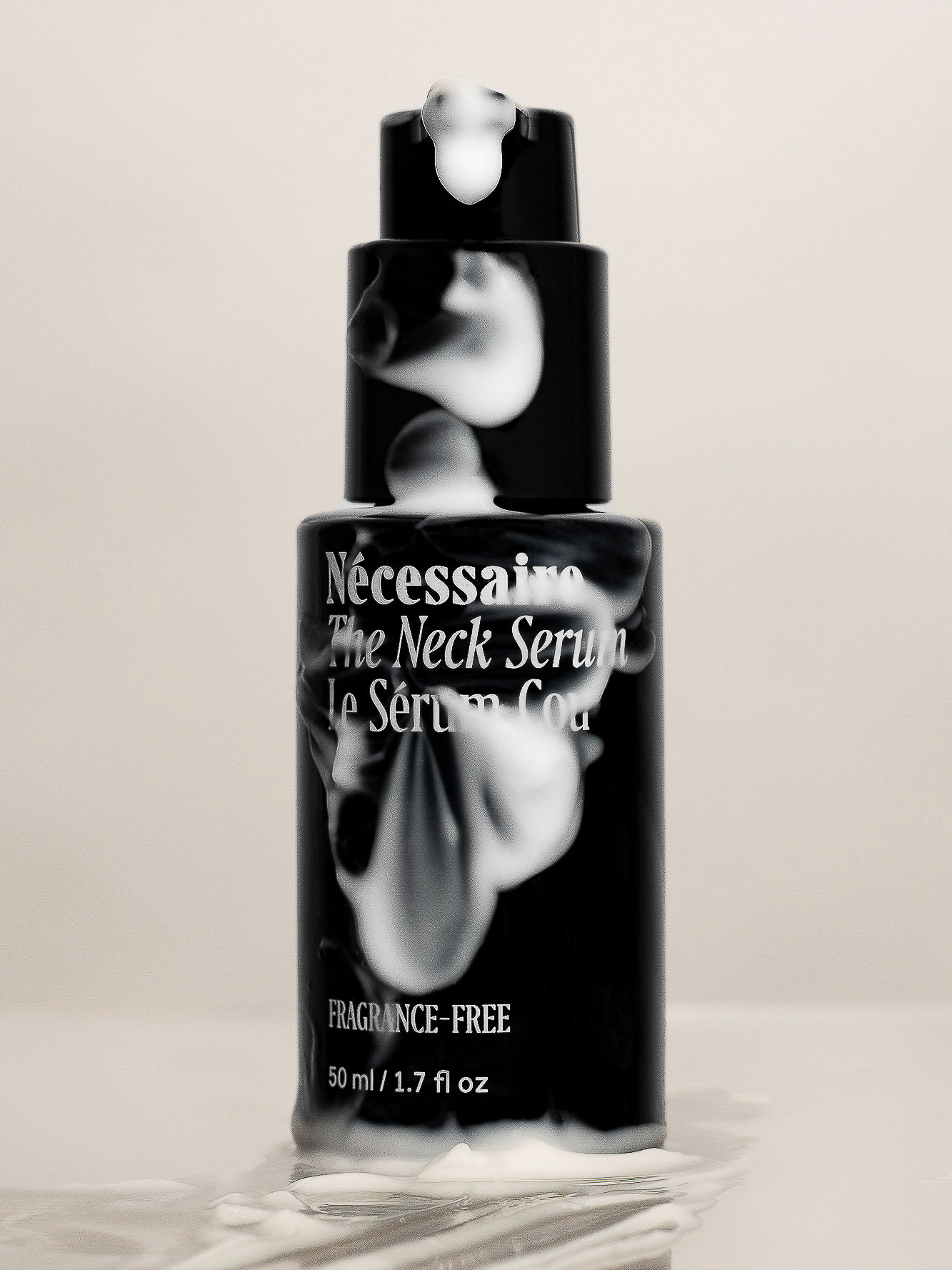 Necessaire The Neck Serum in a black bottle with white foam on a neutral background, product shot for beauty and personal care.