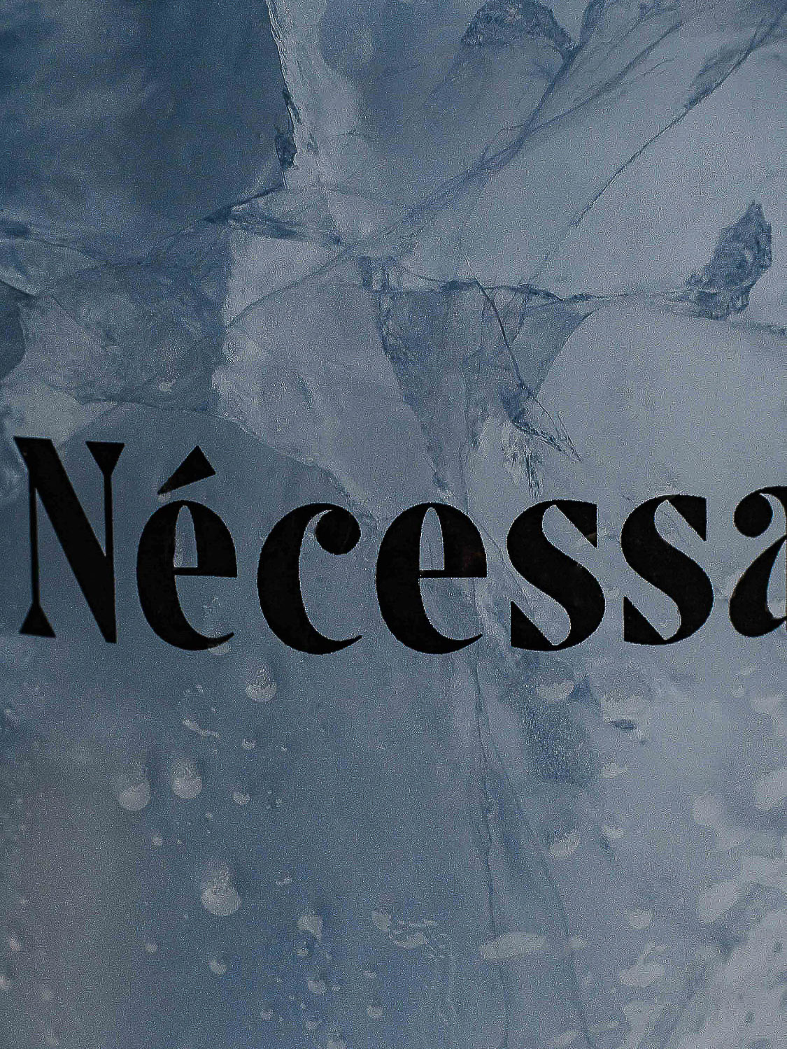 Abstract background image with a cracked ice texture and the word 'Nécessaire' in bold, sans-serif font overlayed on top.