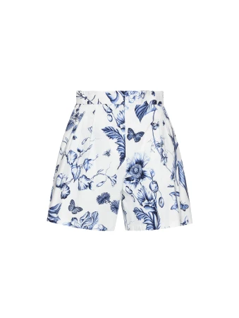 White shorts featuring a blue floral and butterfly pattern. The shorts are high-waisted with a defined waistband and are isolated against a white background.