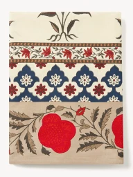 Folded textile featuring floral block-print patterns in red, navy blue, and beige against a plain off-white background.
