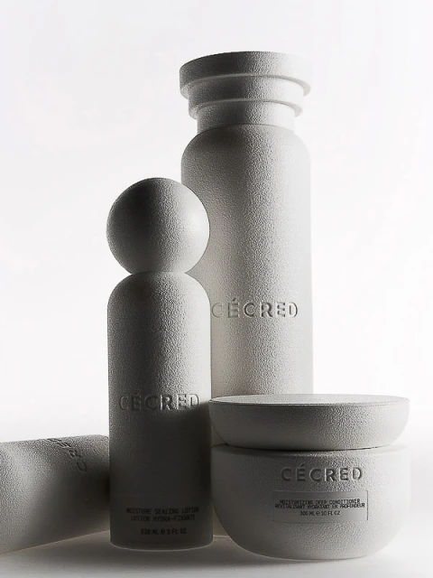 Group of white skincare products including moisturizer and lotion bottles on a white background in a studio setting. Beauty shot.