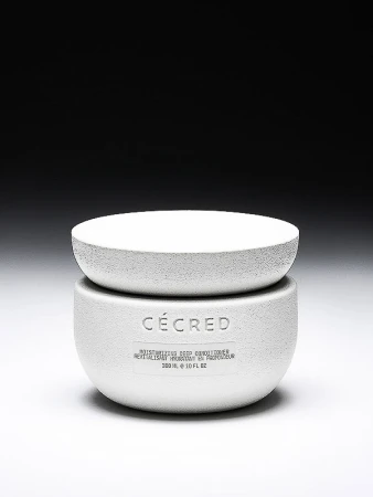 Cécred Moisturizing Deep Conditioner in a white textured jar with a matching lid, set against a gradient black to white background.
