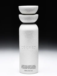 Cecred clarifying shampoo and scalp scrub bottle with textured off-white packaging on a dark to light gradient background.