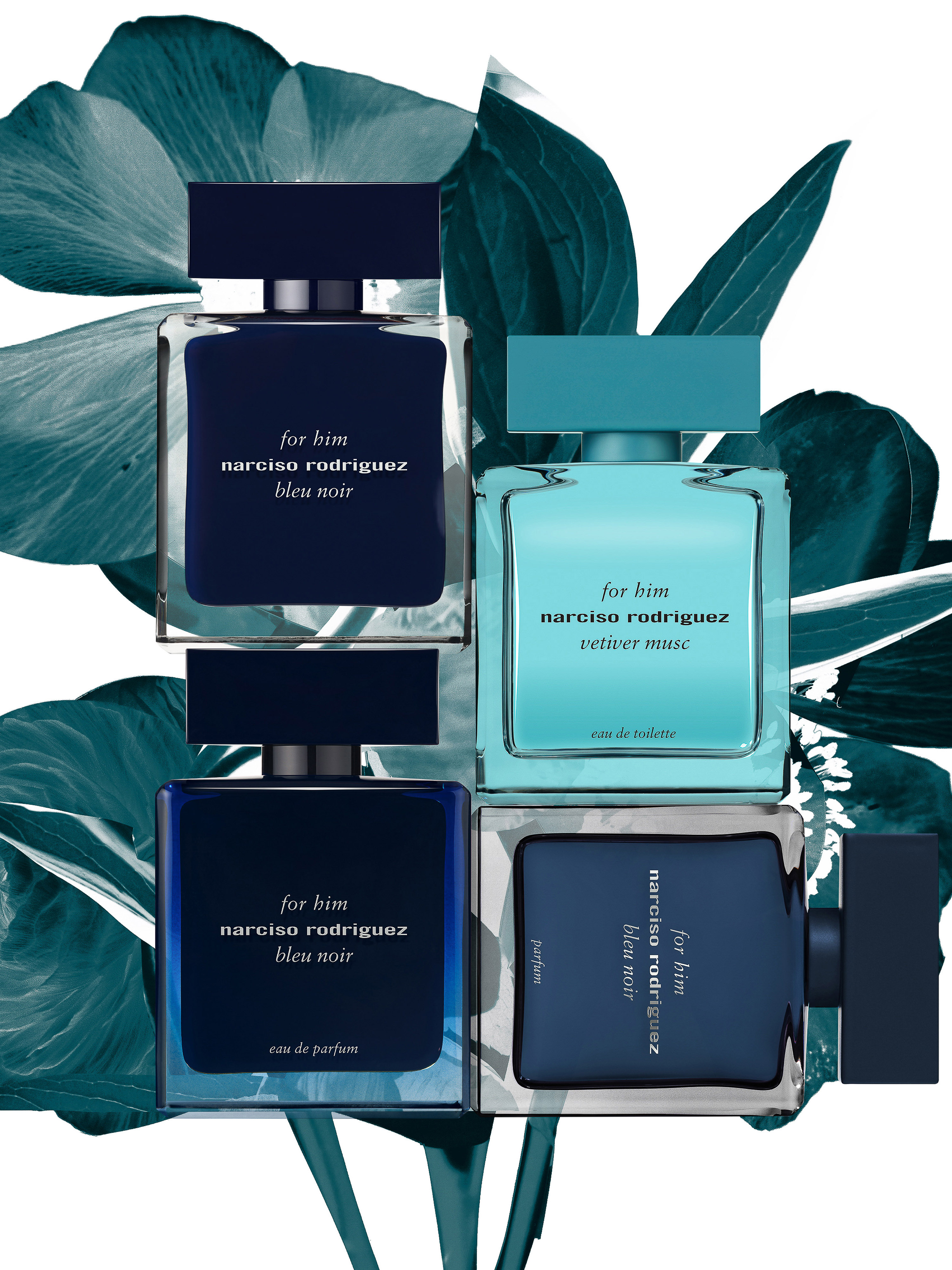 Still life of Narciso Rodriguez 'for him' Bleu Noir and Vetiver Musc fragrances with blue and green accent leaves on a white backdrop.