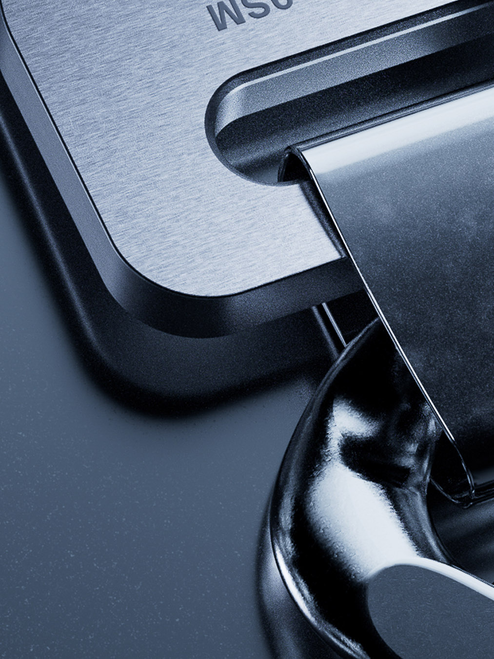 Close-up of a shiny, metallic padlock with a brushed metal surface. The padlock is secured and reflects light. Cool lighting.
