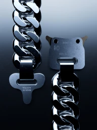 CGI rendering of a silver chunky curb chain necklace with an open metal rollercoaster buckle on a dark gradient background.