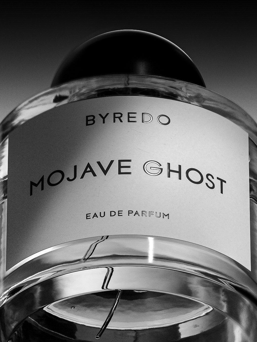 Byredo Mojave Ghost Eau de Parfum bottle close-up in black and white, showcasing a sleek, transparent design with minimalist label.