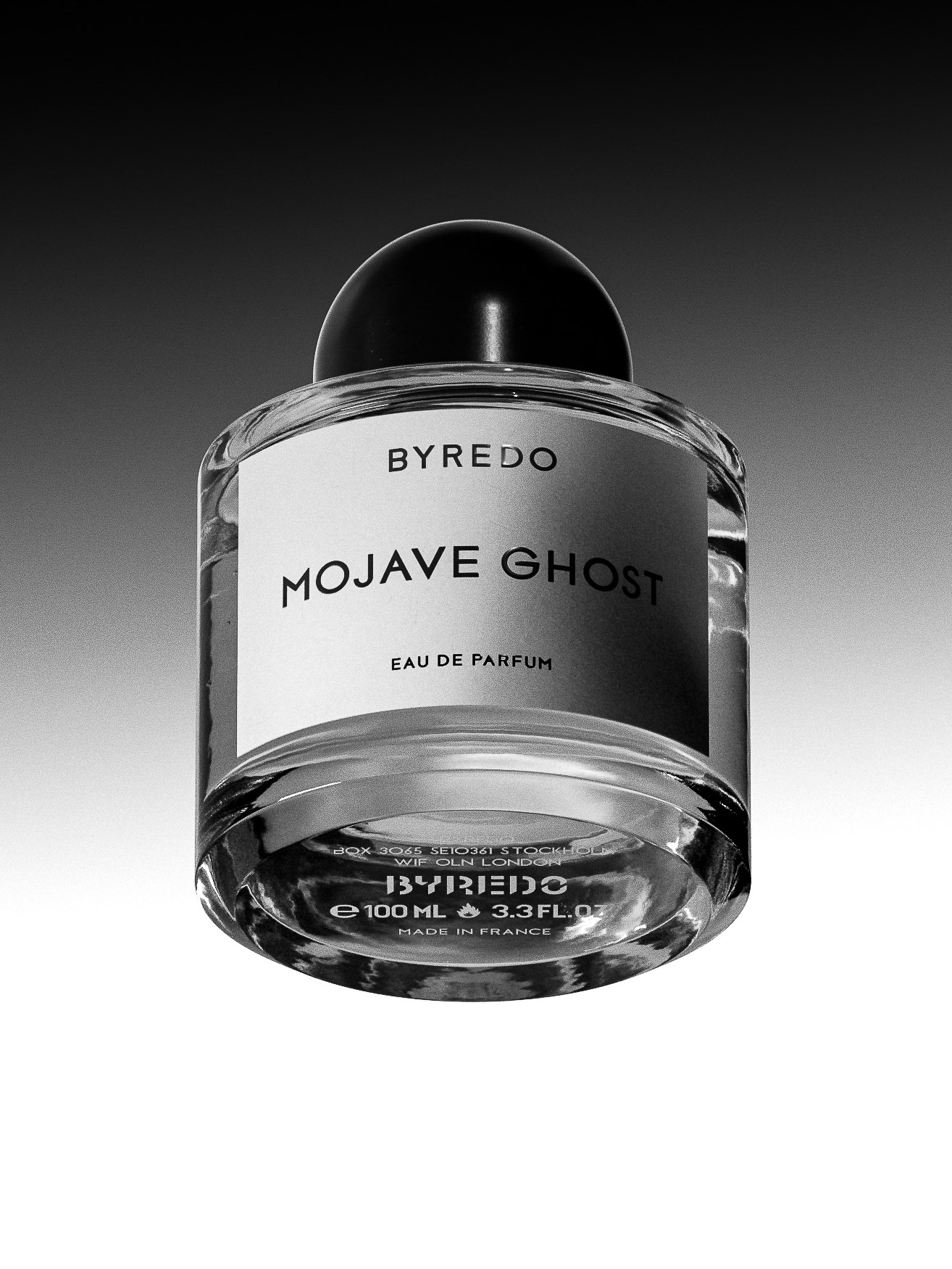 Byredo Mojave Ghost eau de parfum in a clear glass bottle with a black cap and white label, presented against a gradient gray backdrop.