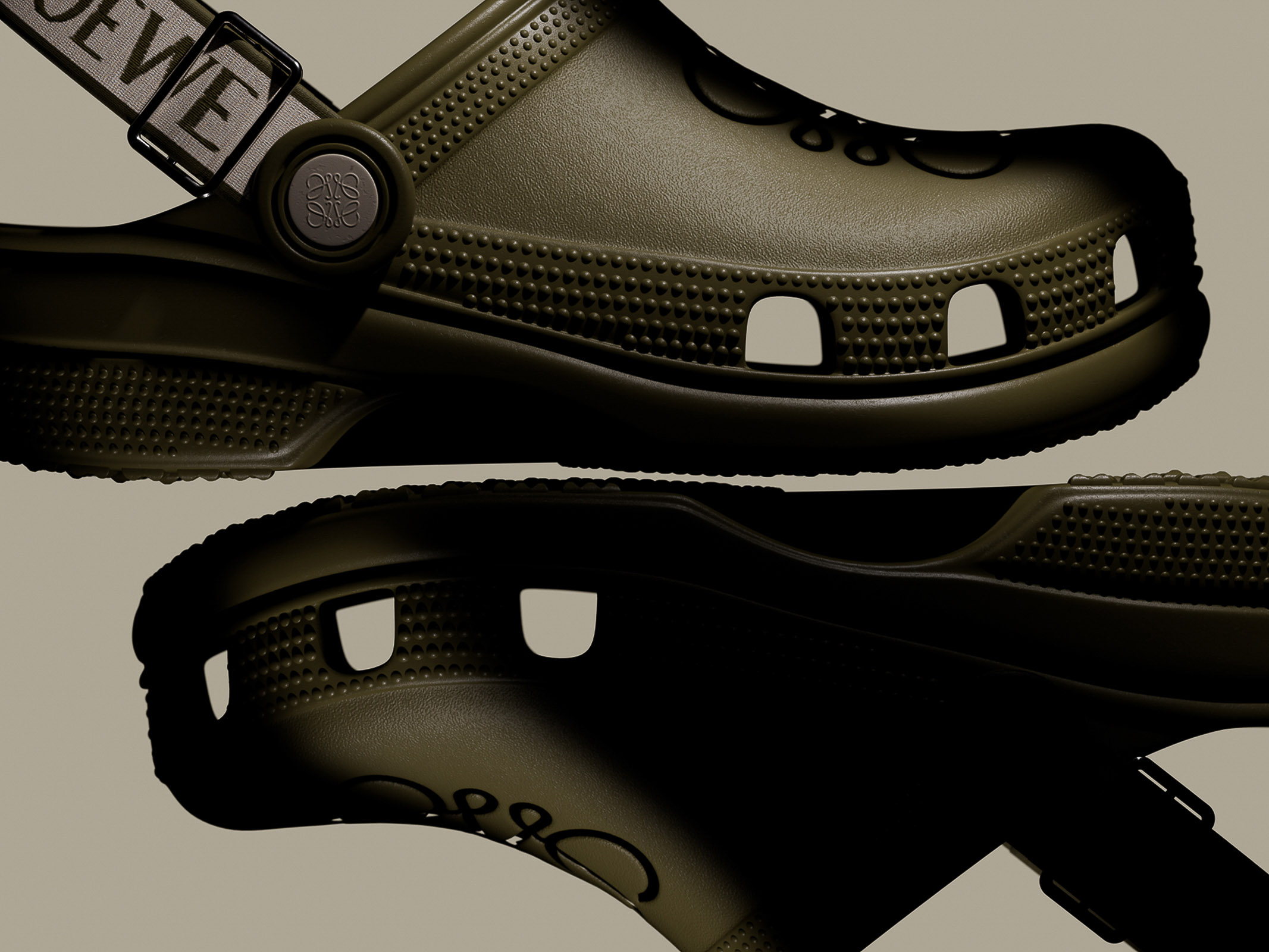 Olive green Croc-style shoes with Loewe straps, showcasing a blend of comfort and high fashion in a studio product shot.