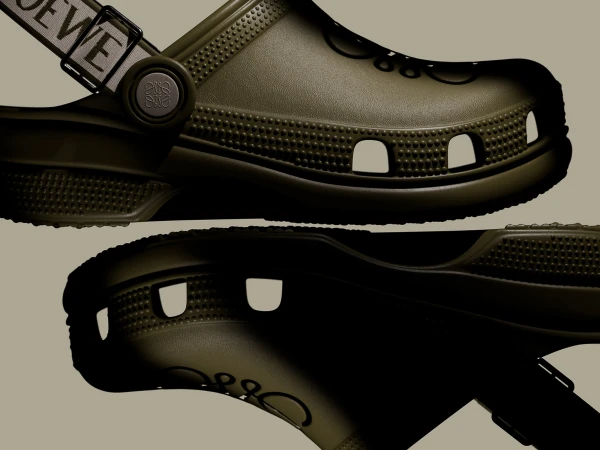 Olive green Croc-style shoes with Loewe straps, showcasing a blend of comfort and high fashion in a studio product shot.