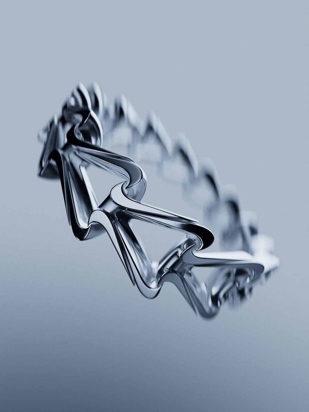 Close-up studio shot of a modern, abstract metal ring with an open, geometric design in front of a graduated grey background.