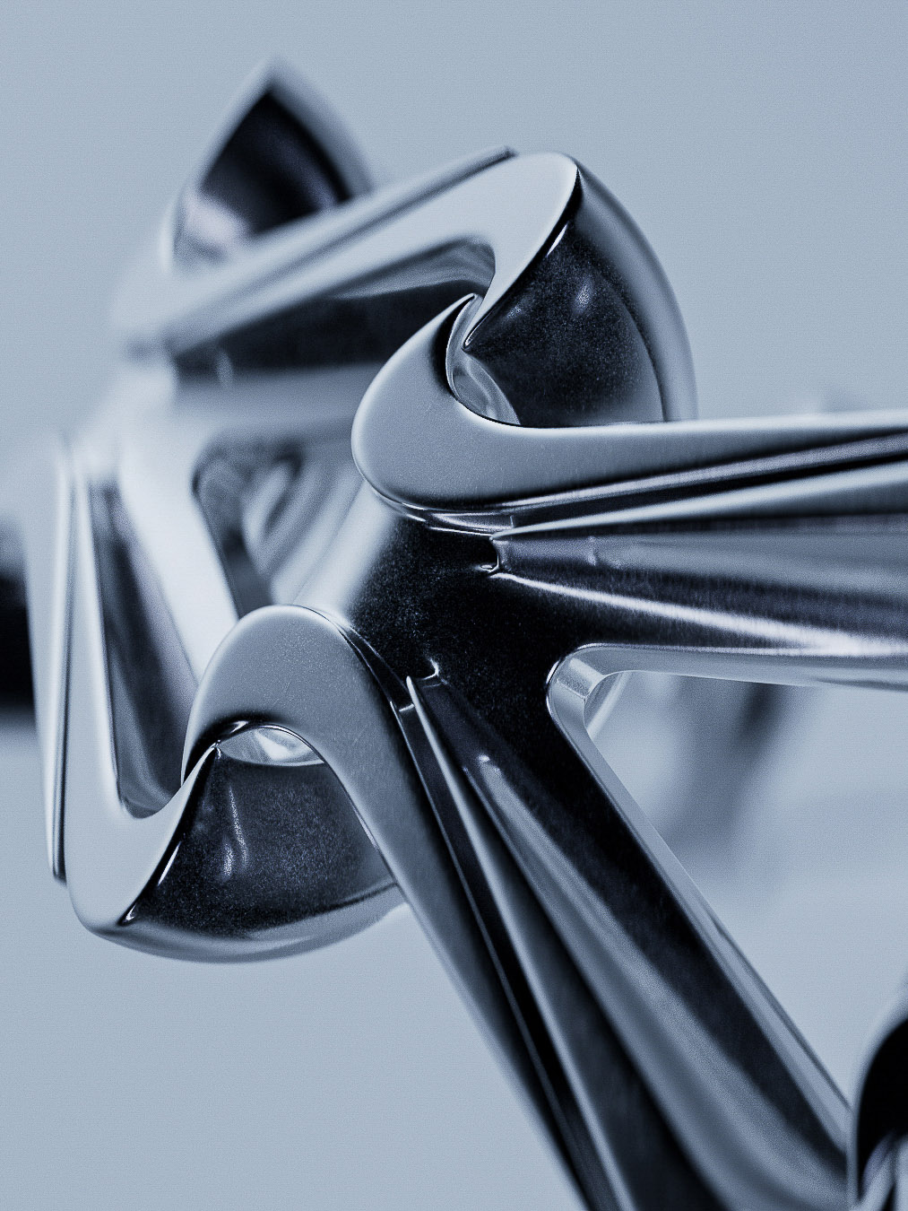 Macro abstract design featuring reflective chrome or silver metal geometric shapes with curved lines and smooth, polished surfaces.