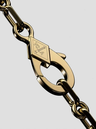 Close-up of a gold chain necklace with a lobster clasp and a diamond-shaped logo, set against a grey backdrop.