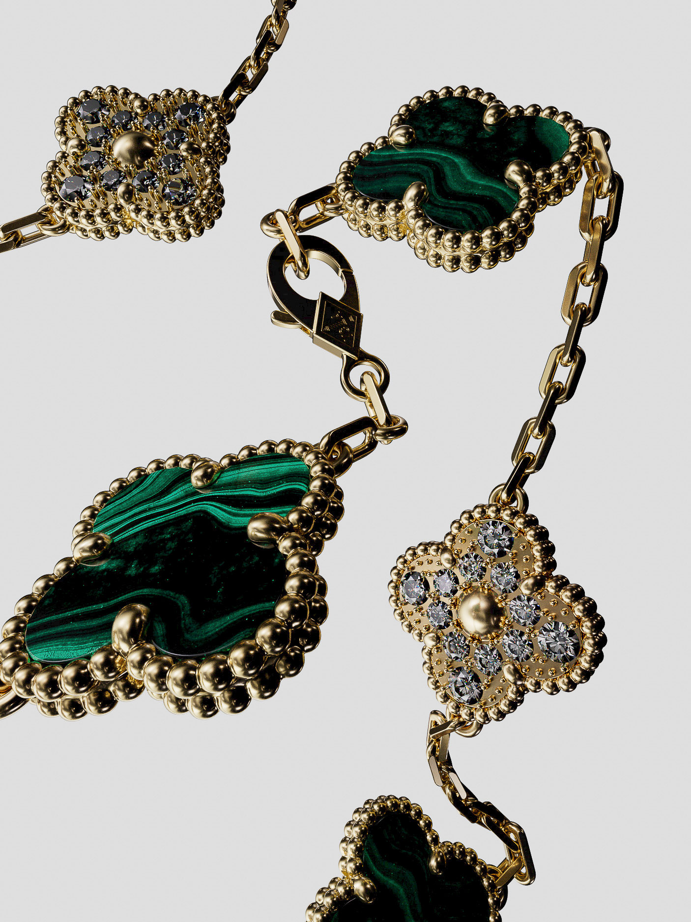 Close-up of a gold chain necklace featuring green malachite and diamond clover-shaped pendants on a neutral background, studio lighting.