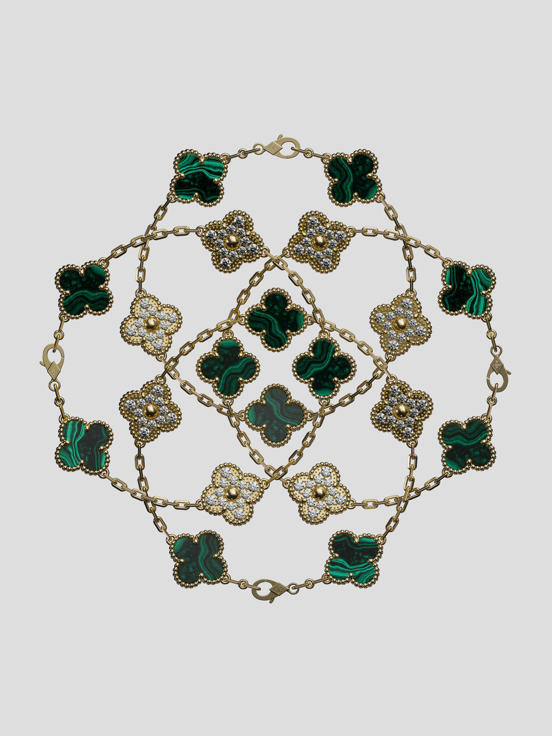 Overhead shot of interlocking gold Van Cleef & Arpels Alhambra bracelets featuring malachite and diamond clover motifs on a grey backdrop.